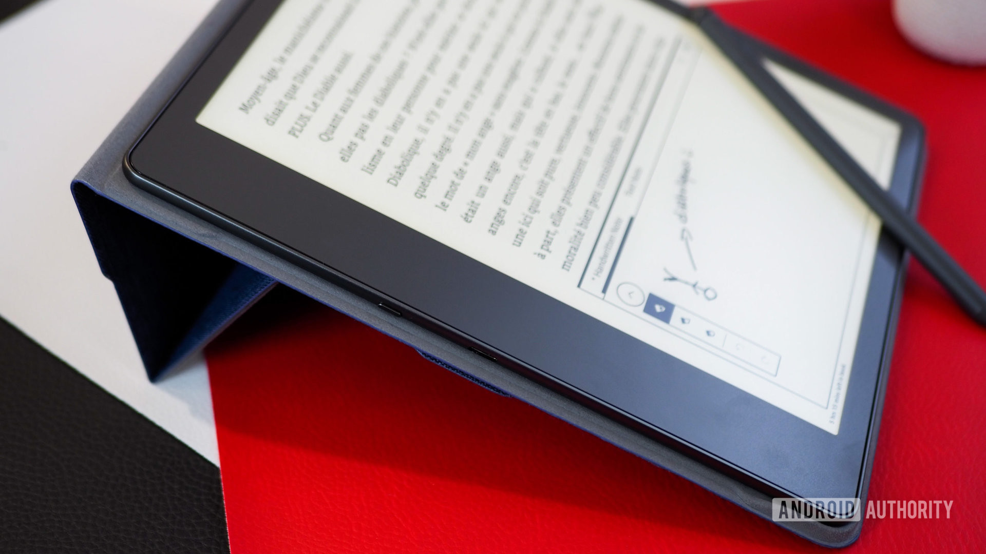Amazon Kindle Scribe's handwritten sticky note, seen from the side, with the reader propped on the official Amazon folio cover
